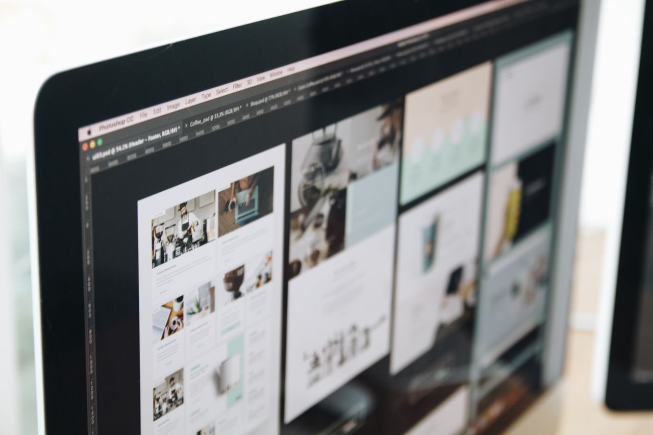 Un écran d’ordinateur moderne montrant un travail de conception web, mettant en valeur des visuels créatifs dans un espace de travail.